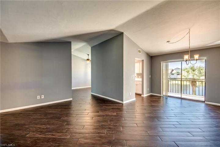 Large Great Room & Dining area with Vaulted Ceilings & Wood Look Tile Floors. Sliding Glass Doors lead to a Large Lanai with Lake & Fountain Views!
