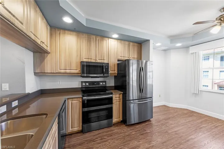 Kitchen with a sink, stainless steel appliances, recessed lighting, ceiling fan, and dark wood-style flooring