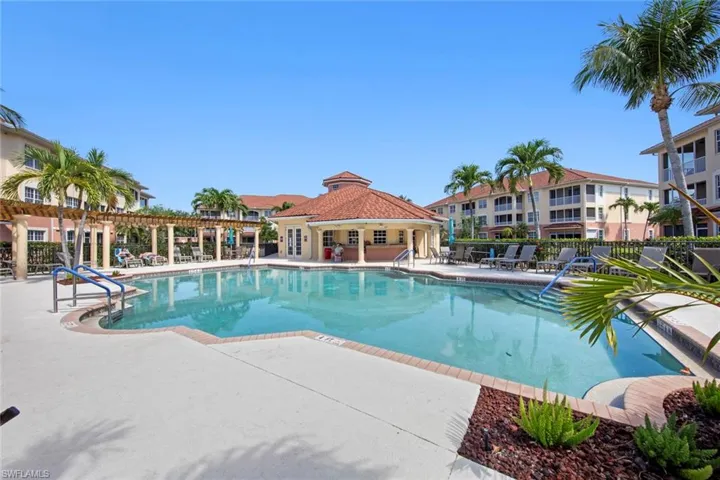 Community pool with a patio and fence