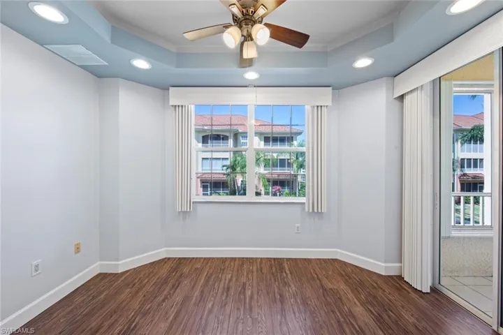 eat in breakfast room featuring a raised ceiling, dark wood-type flooring, and recessed lighting