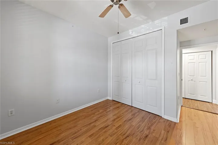 Unfurnished bedroom with baseboards, a closet, light wood-style flooring, and visible vents