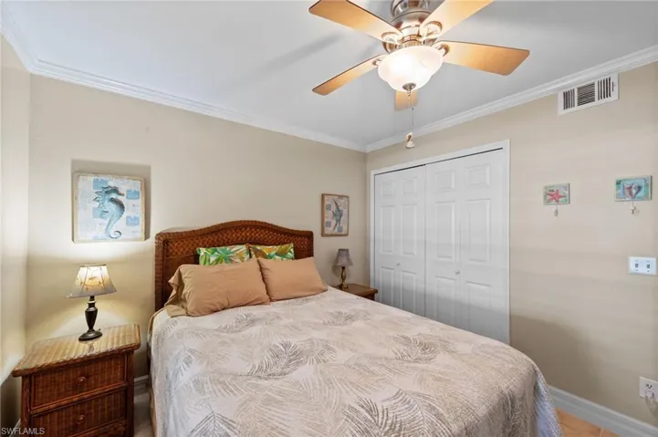 Bedroom with ornamental molding, a closet, and a ceiling fan