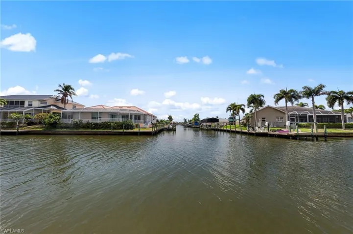Water view featuring nearby suburban area and a dock