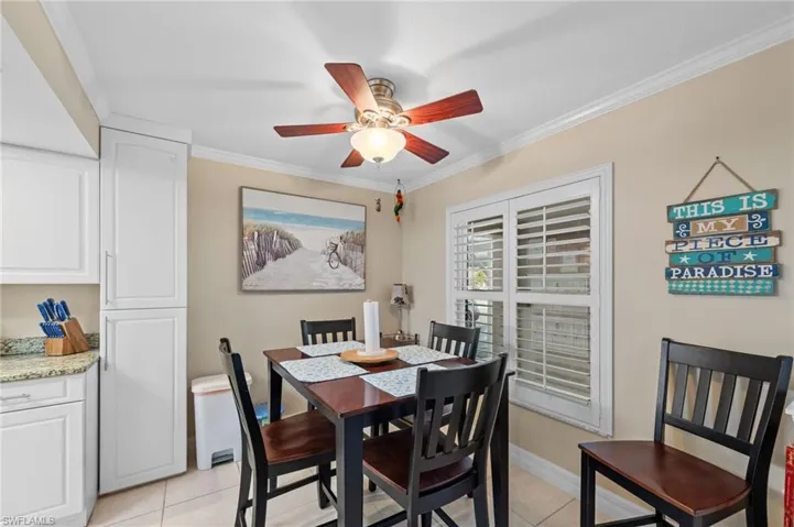 Dining area featuring ornamental molding, light tile patterned floors, and a ceiling fan