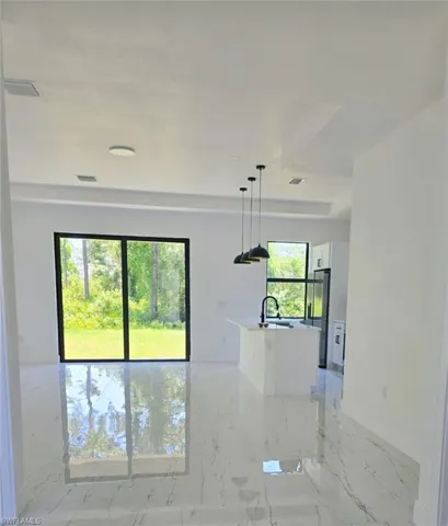 Unfurnished room featuring light marble finish flooring and a sink