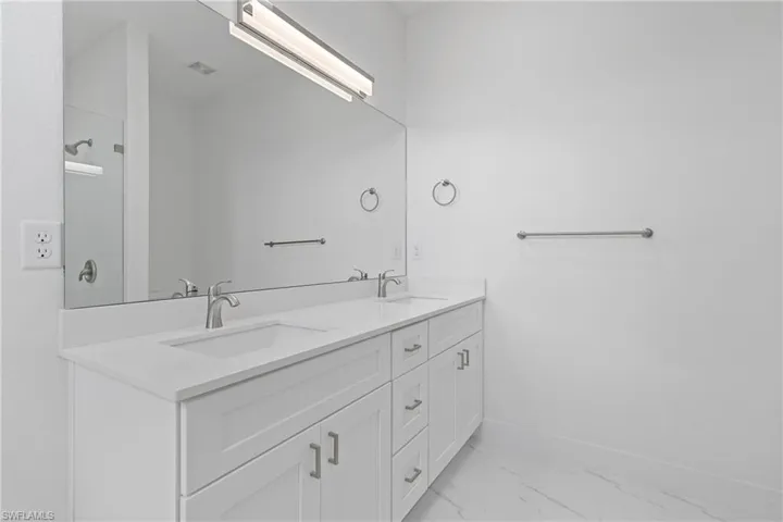 Bathroom featuring marble look tiles and double vanity