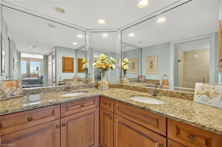 Ensuite bathroom with double vanity, recessed lighting, and a tile shower