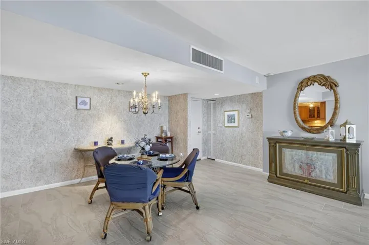 Dining space featuring a chandelier and wallpapered walls