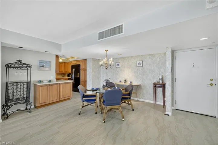 Dining space featuring wallpapered walls and a chandelier