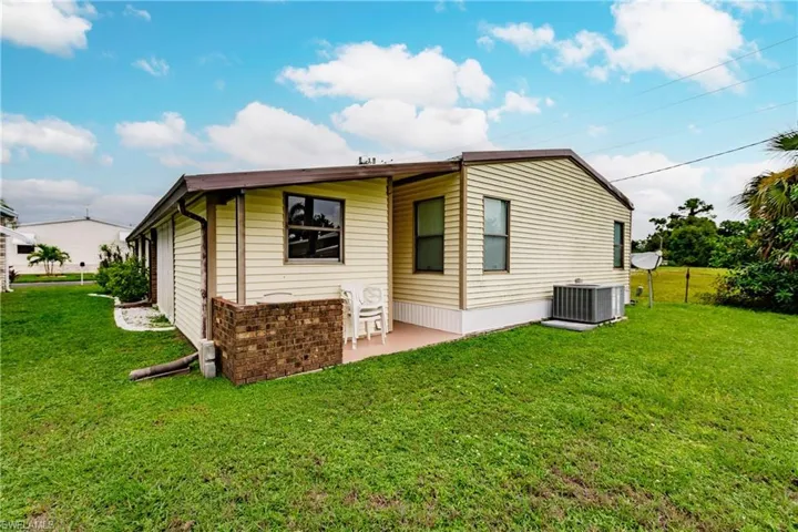 Back of property featuring a patio, central AC, and a yard
