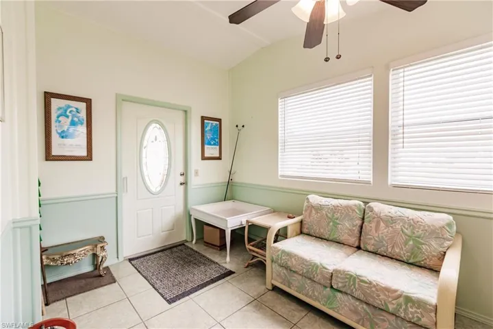 Tiled foyer with ceiling fan, vaulted ceiling, and plenty of natural light
