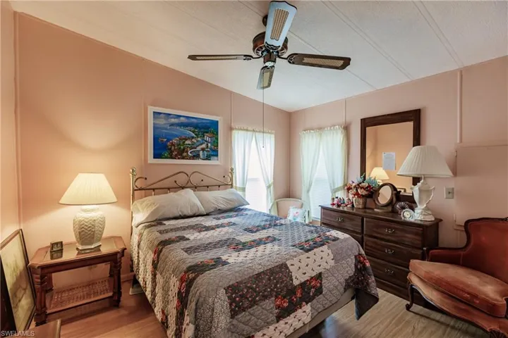 Bedroom featuring ceiling fan, light hardwood / wood-style floors, and lofted ceiling