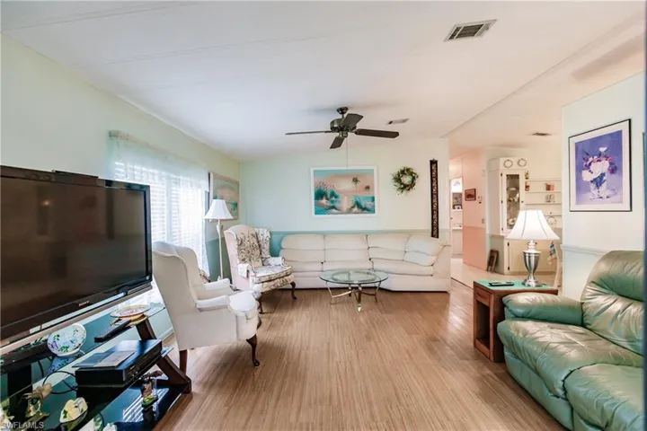 Living room featuring ceiling fan and light hardwood / wood-style flooring