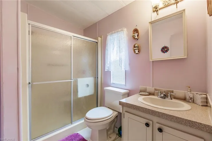 Bathroom with a shower with door, toilet, and vanity
