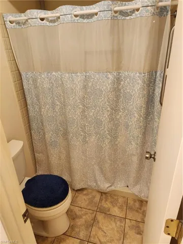 Bathroom featuring curtained shower and tile patterned flooring