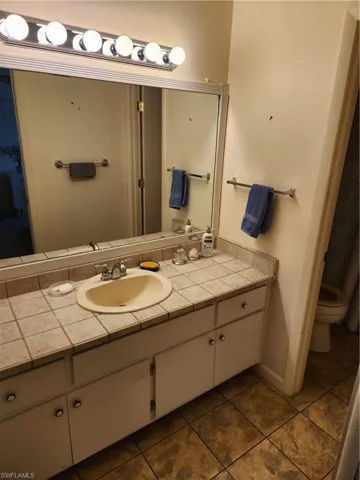 Bathroom featuring vanity and dark tile patterned floors