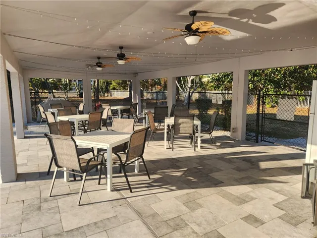 Sunroom with outdoor dining space, a patio area, and a ceiling fan