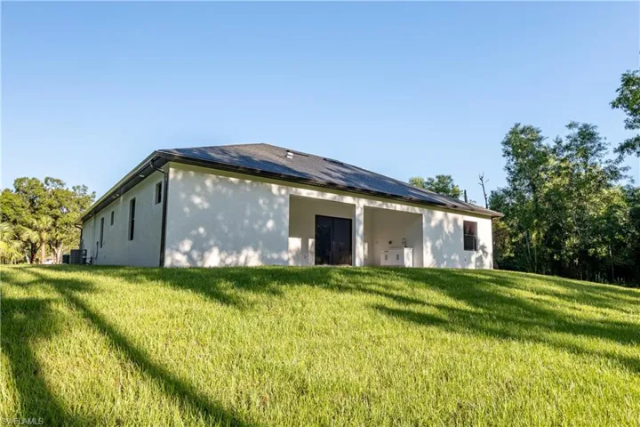 View of side of home featuring central AC and a yard