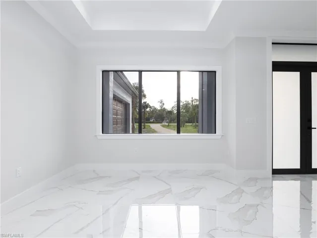 Empty room featuring a raised ceiling and light tile patterned floors