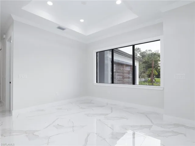 Spare room featuring a tray ceiling and tile patterned flooring