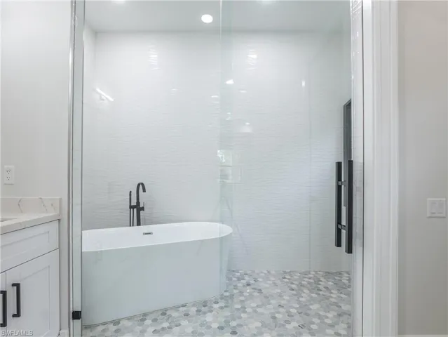 Bathroom featuring tile patterned floors, vanity, and independent shower and bath
