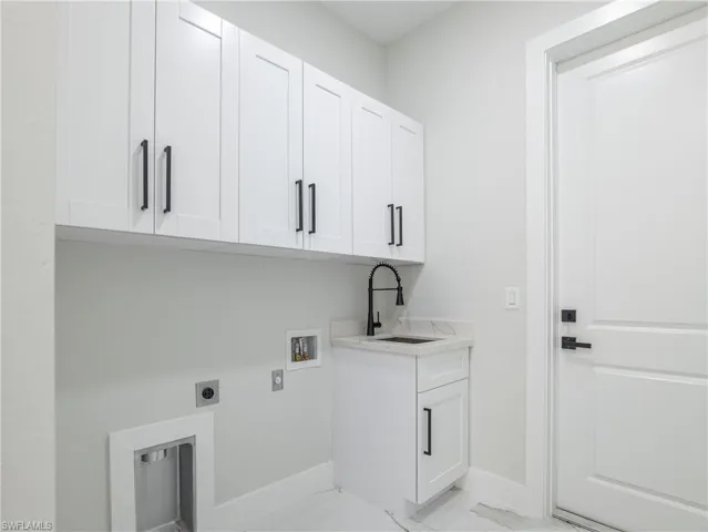Laundry area featuring hookup for a washing machine, light tile patterned floors, cabinets, electric dryer hookup, and sink