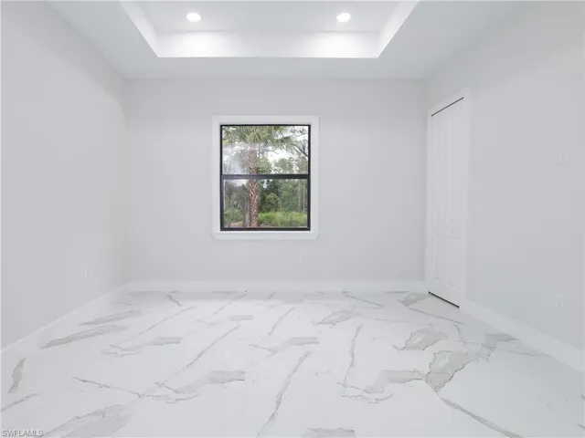 Spare room featuring tile patterned floors and a raised ceiling