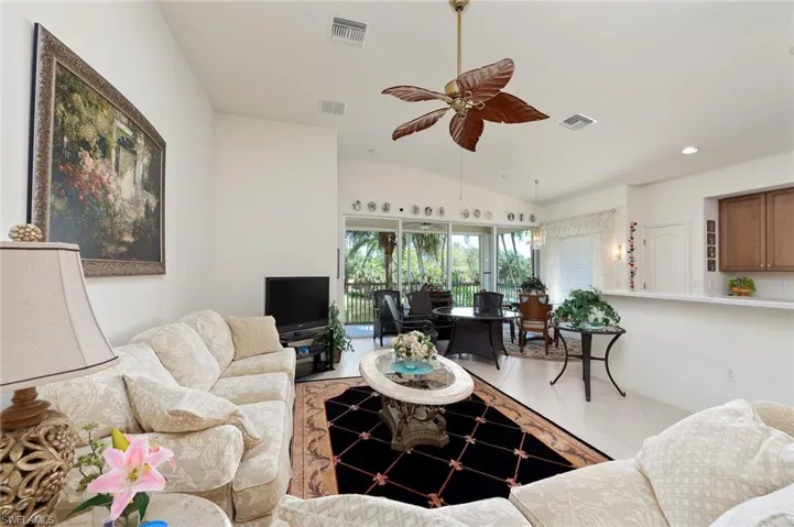 Tiled living room with vaulted ceiling and ceiling fan