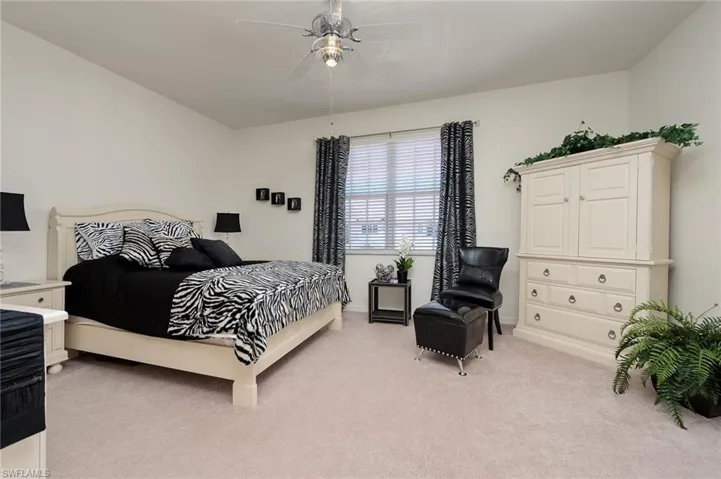 Bedroom with light carpet and ceiling fan