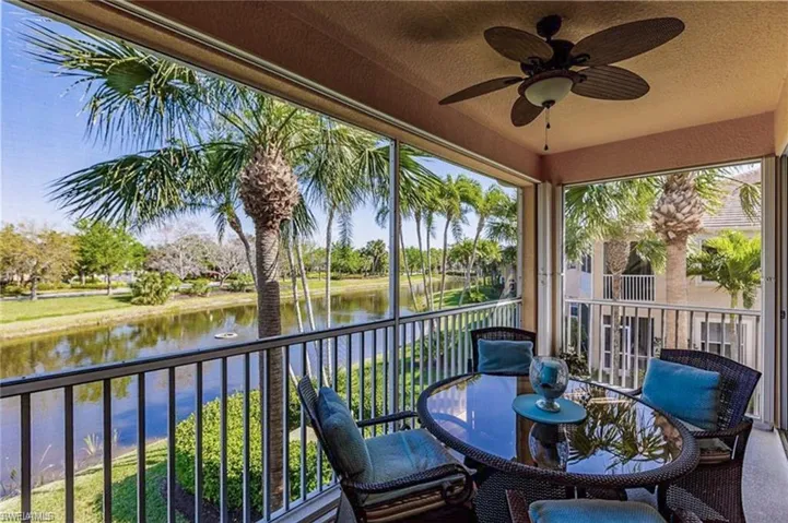 Sunroom with ceiling fan and a water view