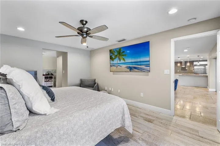 Bedroom featuring ceiling fan, stainless steel refrigerator, and light tile floors