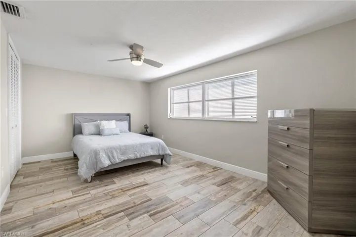 Bedroom with a closet, ceiling fan, and light wood-type flooring