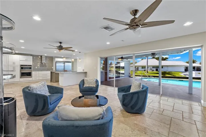 Living room with ceiling fan and light tile flooring