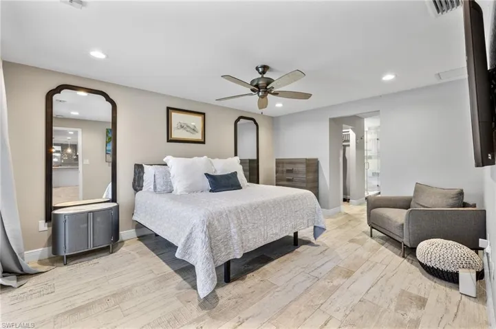 Bedroom featuring ceiling fan, connected bathroom, and wood-type flooring