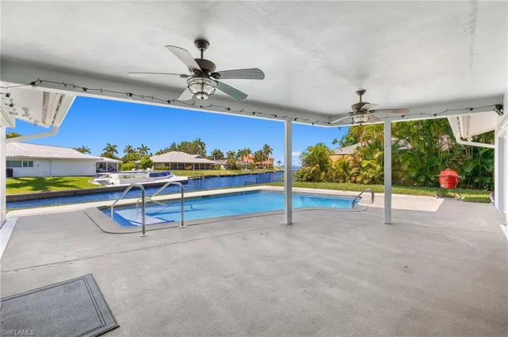 View of pool with ceiling fan and a patio