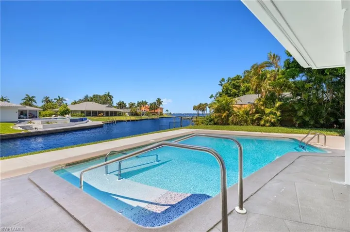 View of swimming pool featuring a water view and a patio area