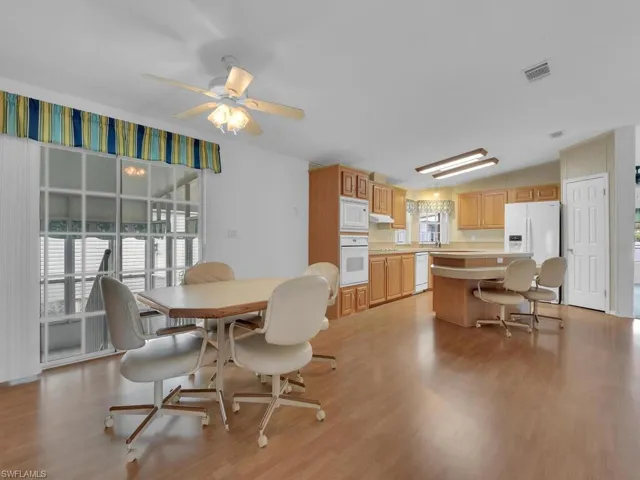 Dining area with ceiling fan, light hardwood / wood-style floors, and lofted ceiling