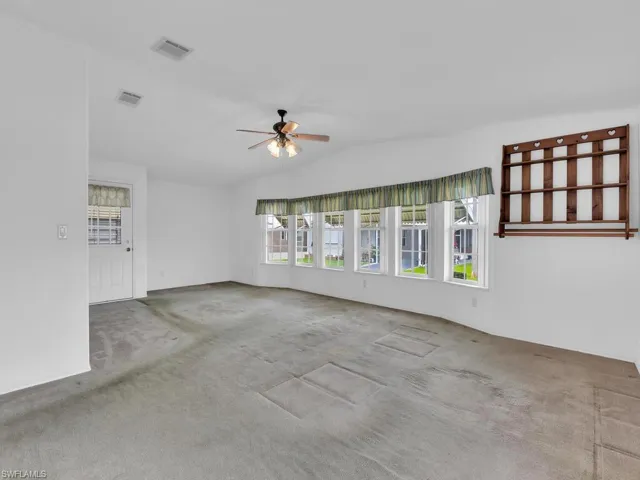 Unfurnished room with carpet, ceiling fan, and lofted ceiling