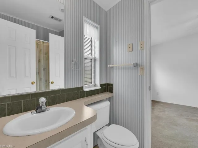 Bathroom with vanity, toilet, and crown molding
