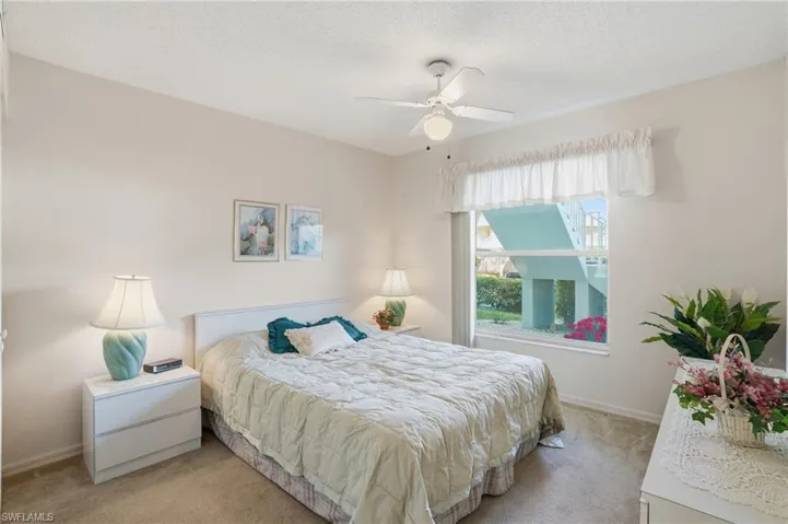 Carpeted bedroom featuring a textured ceiling and a ceiling fan