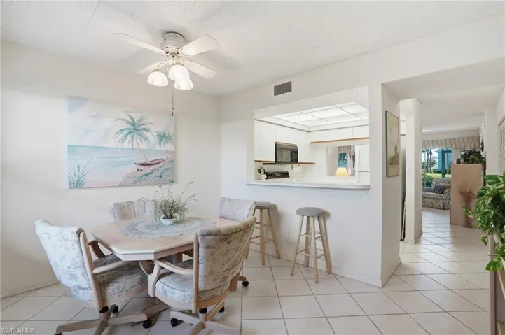 Dining area featuring a textured ceiling, ceiling fan, and light tile patterned flooring