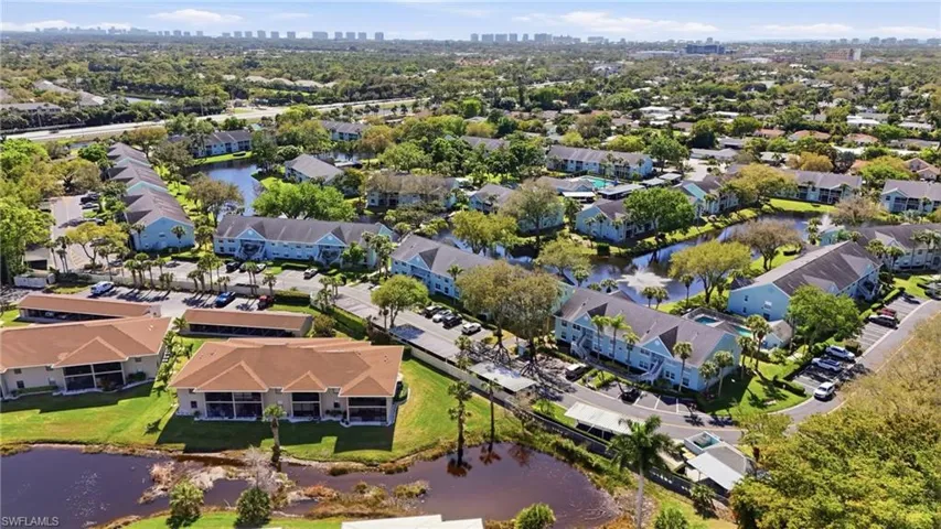 Aerial perspective of suburban area with city skyline and a nearby body of water