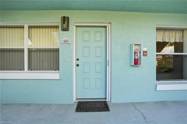 Doorway to property featuring stucco siding