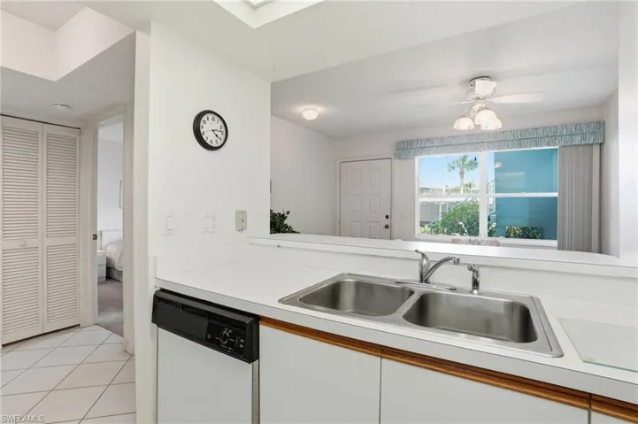 Kitchen with light countertops, dishwasher, white cabinetry, a ceiling fan, and light tile patterned floors