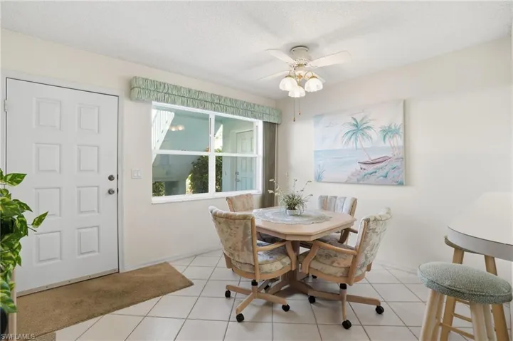 Dining area featuring a ceiling fan, a textured ceiling, and light tile patterned floors