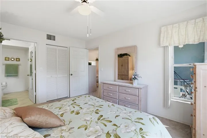 Bedroom featuring a closet, ensuite bathroom, and a ceiling fan