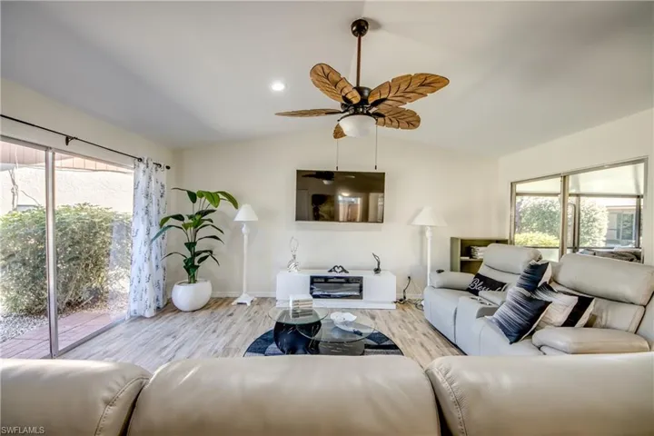 Living room featuring wood finished floors, vaulted ceiling, recessed lighting, and a ceiling fan