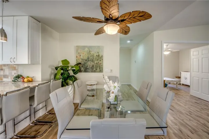 Dining space with light wood-style flooring and ceiling fan