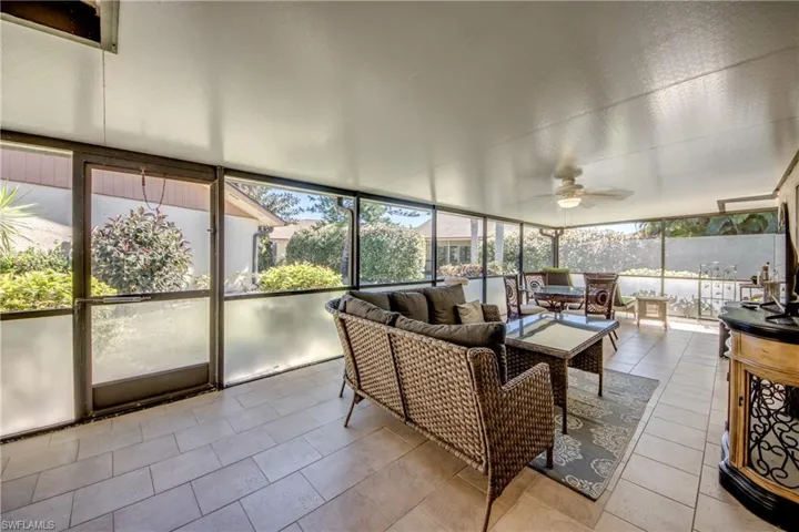 Sunroom / solarium featuring a ceiling fan and an outdoor living / dining area