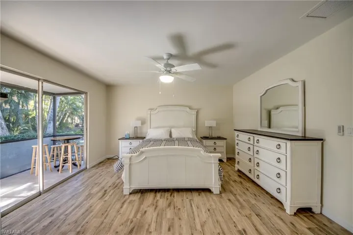 Bedroom with access to exterior, light wood-style flooring, and a ceiling fan